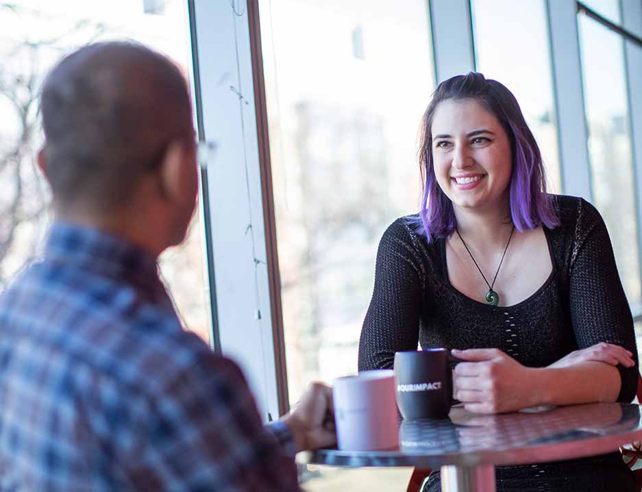 Foto van twee medewerkers die een gesprek voeren