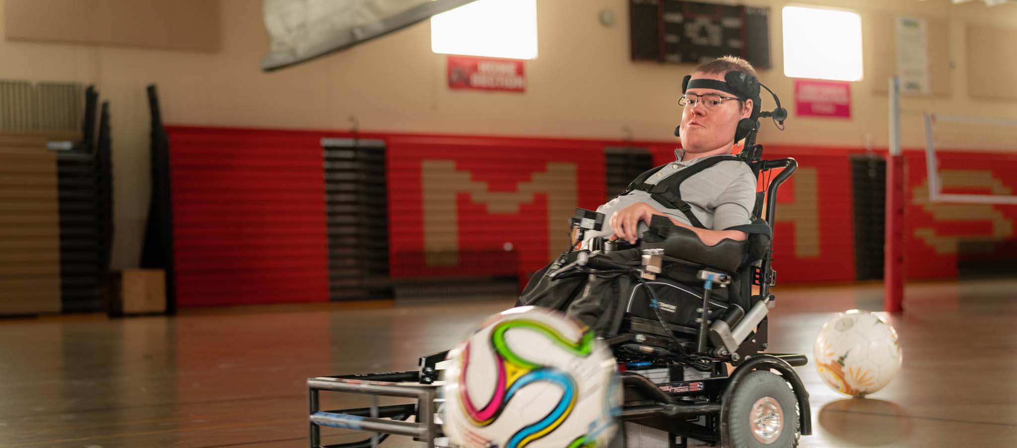 Nathan in een gymzaal spelend met een voetbal